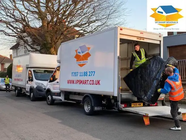 London professional movers carefully lifting wrapped furniture onto a moving truck