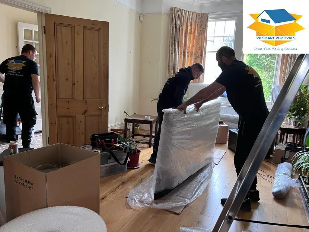 London movers putting safety wrap around a table in a huge house removal